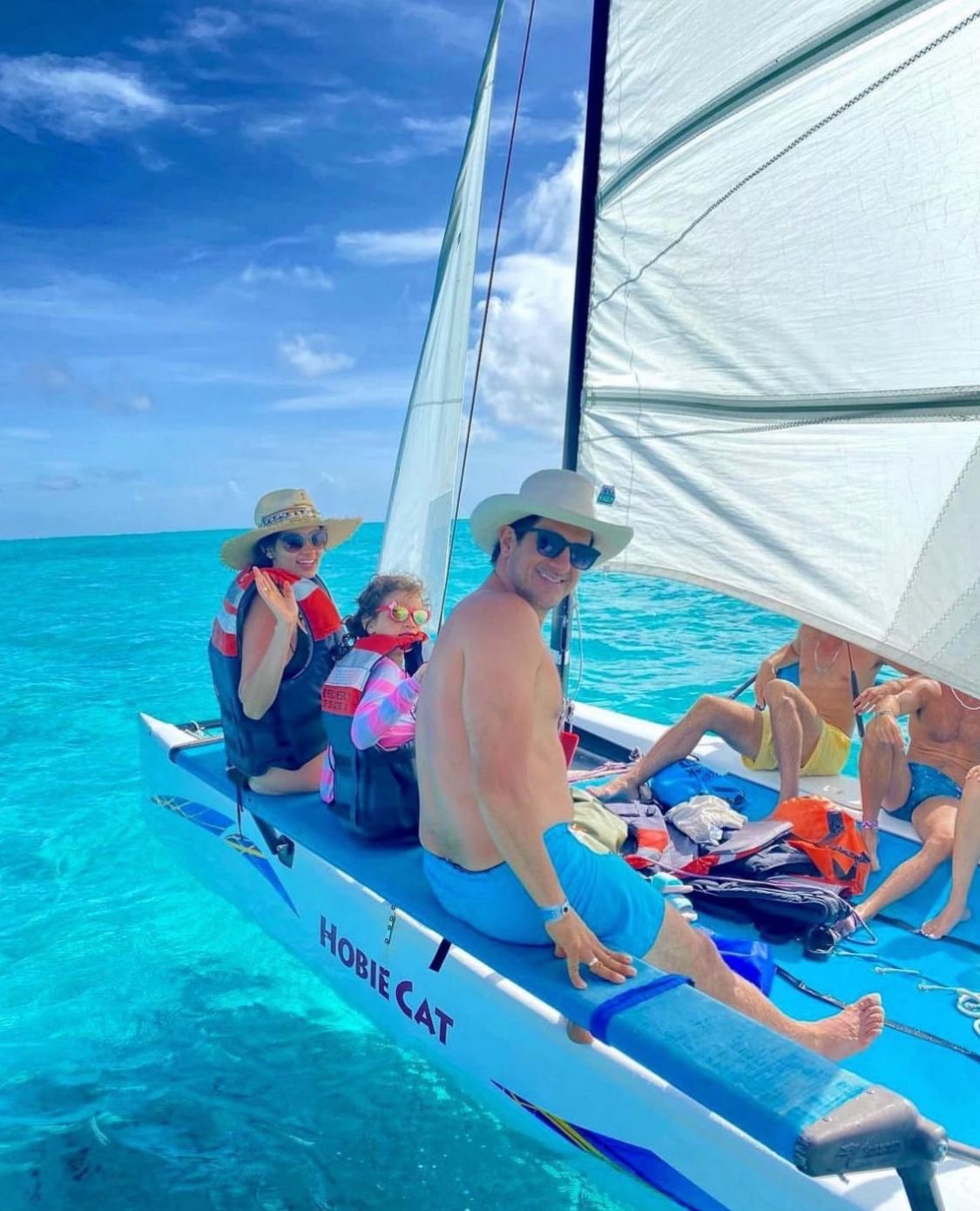 Familia navegando en Hobie Cat sobre aguas turquesa