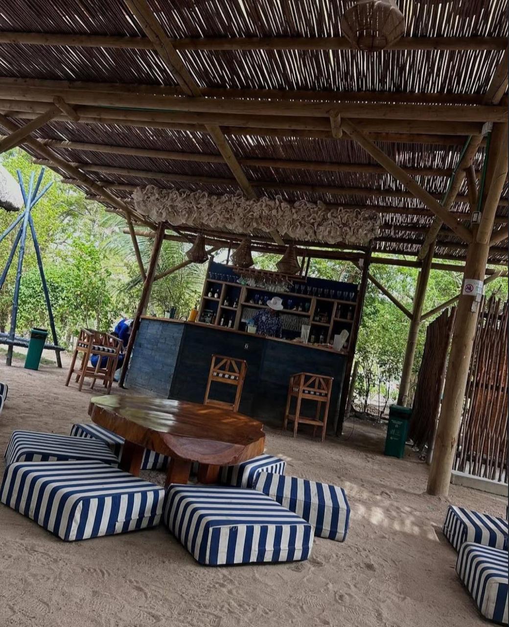 Zona chillout con cojines azul y blanco bajo enramada