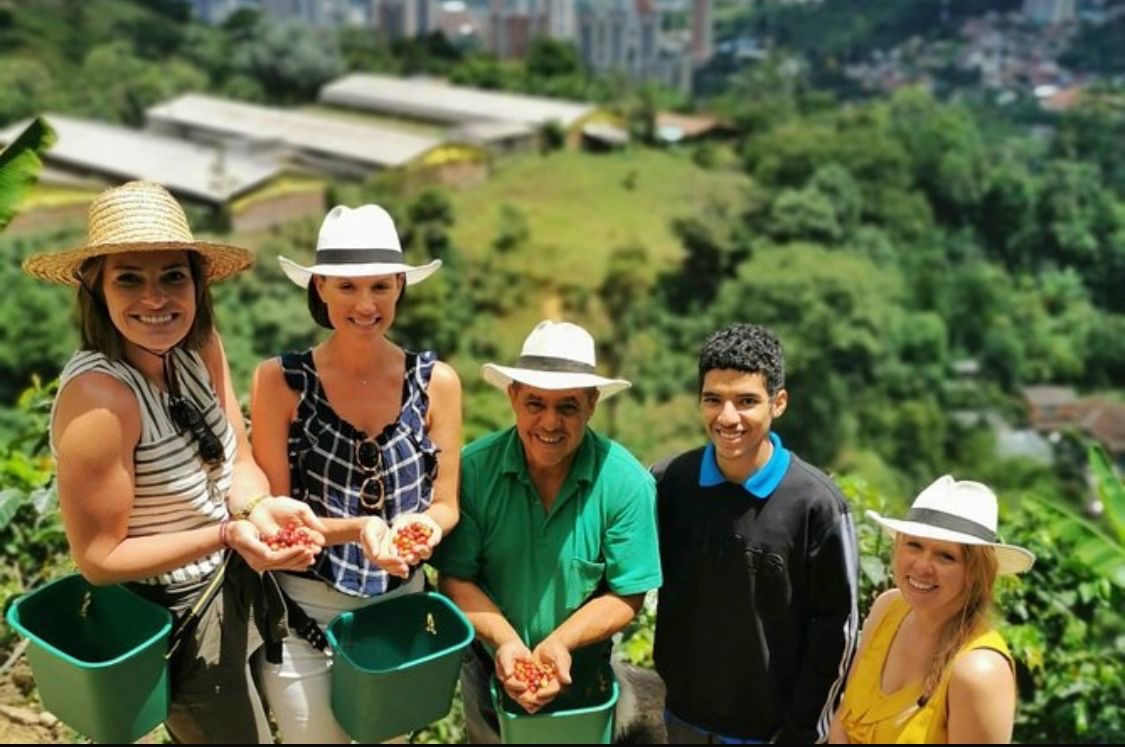Familia cafetera mostrando granos recién cosechados