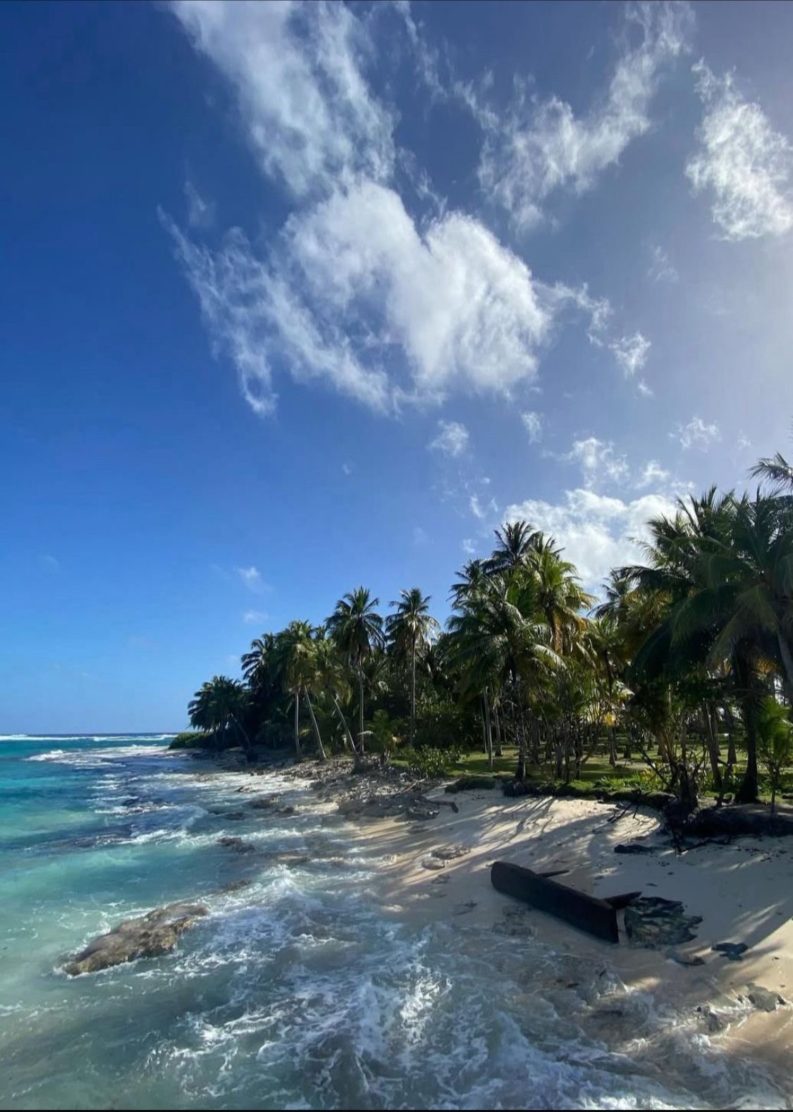 Playa de Jhony Cay con palmeras y oleaje suave