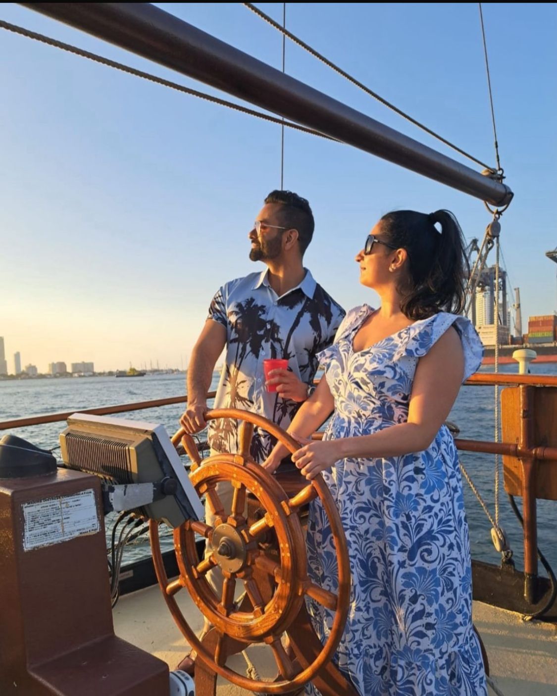 Pareja al timón del barco pirata al atardecer