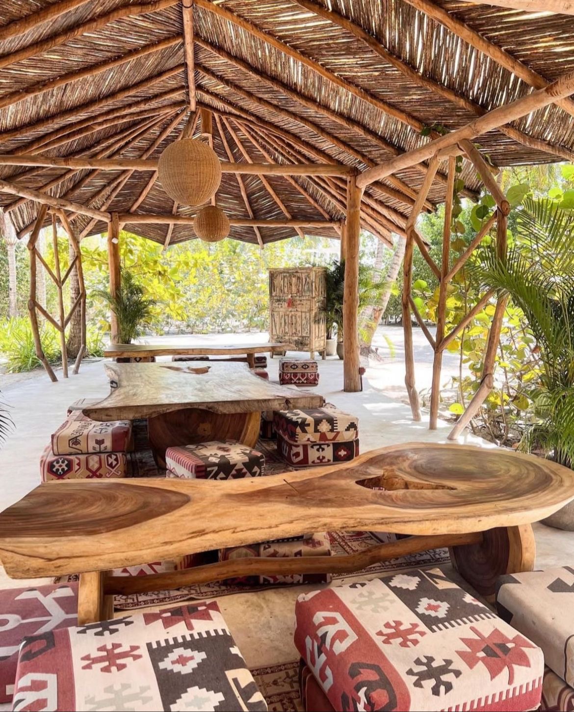 Comedor con mesas de madera y cojines kilim