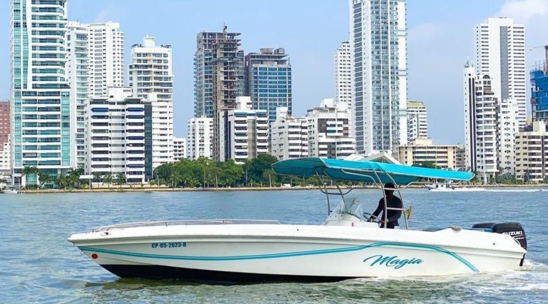Bote Magia navegando frente al skyline de Cartagena