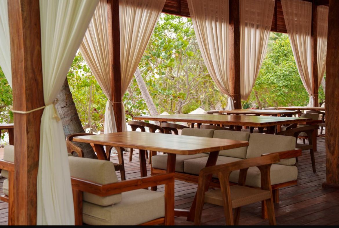 Comedor con cortinas blancas y mesas de madera