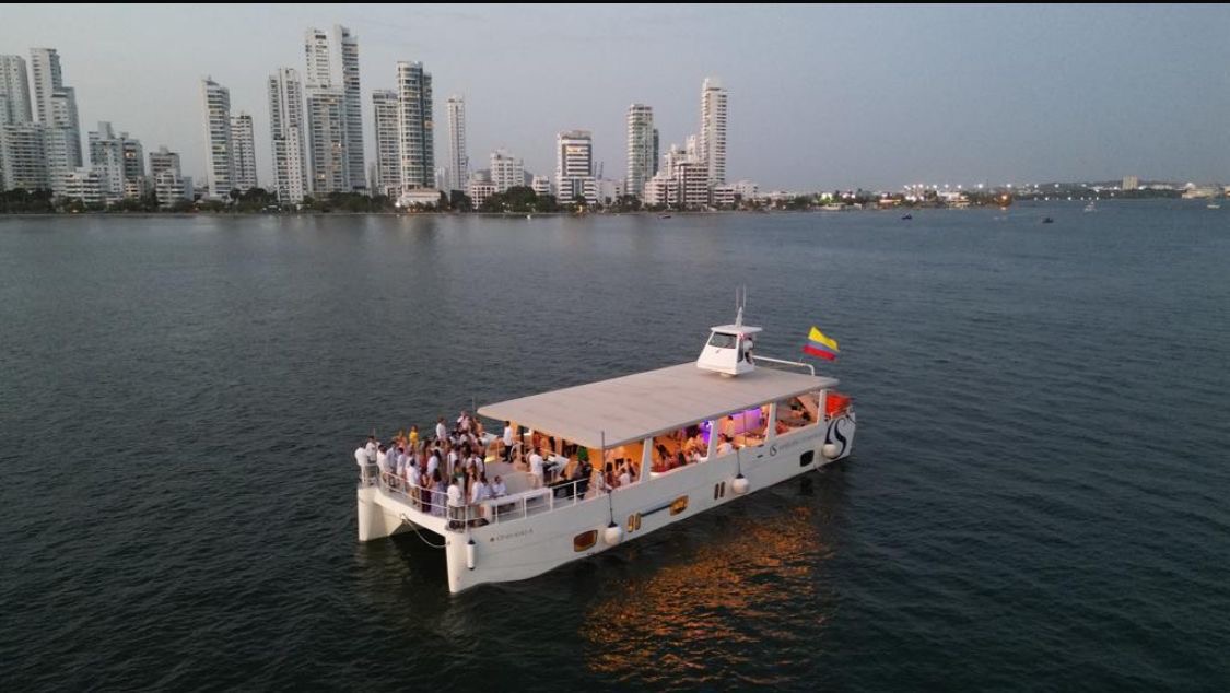 Catamarán con invitados frente a la ciudad amurallada