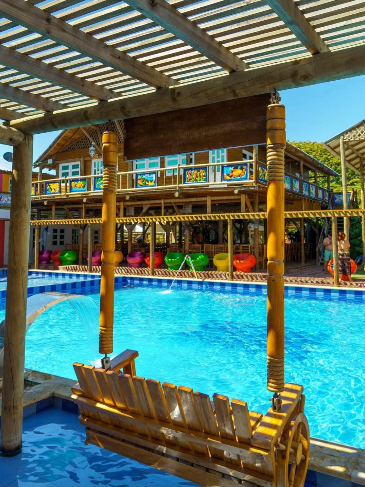 Piscina de cascada bajo pérgola de bambú